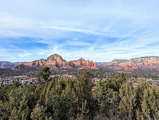 A "wall" of red rock formations rises up above the town of Sedona